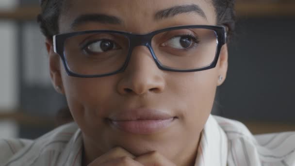 Tvivel koncept. Närbild av unga skeptiska afrikanska amerikanska kvinna bär glasögon tittar allvarligt på kameran — Stockvideo