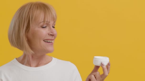 Anti-Aging Skincare. Starší dáma drží sklenici s hydratační krém a kývající hlavou — Stock video