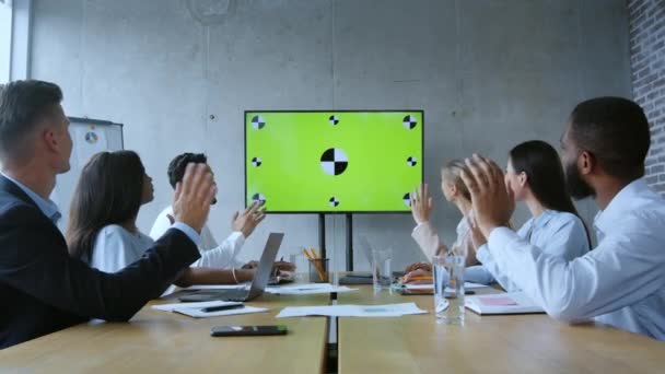 Современная виртуальная конференция. Снимок молодой многоэтнической бизнес-команды, смотрящей на цифровой экран с зеленой хромой — стоковое видео