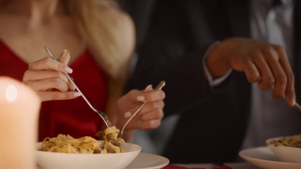 イタリア料理店でロマンチックなディナー中にパスタを食べる認識できないカップル — ストック動画