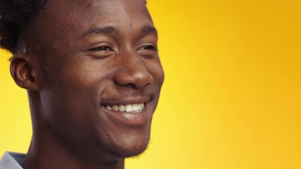 Un estilo de vida positivo. Primer plano del joven afroamericano feliz riendo felizmente sobre el fondo amarillo, espacio libre — Vídeos de Stock