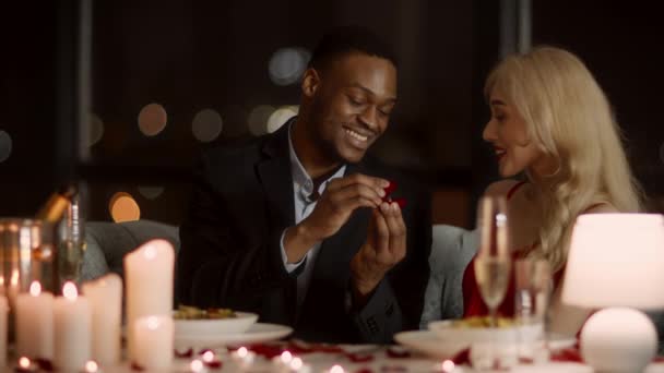 African Man gör förslag till flickvän visar ring i restaurang — Stockvideo