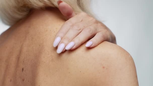 Cura del corpo. Primo piano colpo di donna matura irriconoscibile applicare crema coccole sulla spalla nuda — Video Stock