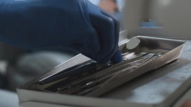 Profesyonel diş tedavisi. Diş hekiminin eli diş aletlerini alıyor ve Afrikalı Amerikalı kadın hastaların dişlerini incelemeye başlıyor.