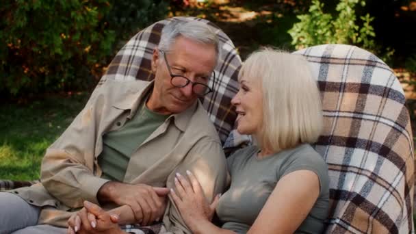 Małżeństwo senior para relaks na świeżym powietrzu w wiklinowych krzesłach, czat i całowanie — Wideo stockowe