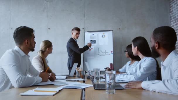 Manager fiducioso uomo fare presentazione a diversi colleghi, la pianificazione di una nuova strategia finanziaria in ufficio, zoom in — Video Stock