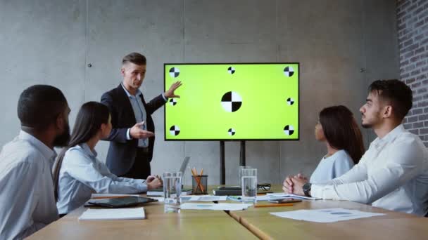 Jefe hombre motivado haciendo presentación a sus colegas, explicando la información sobre la pantalla digital de croma verde clave — Vídeos de Stock