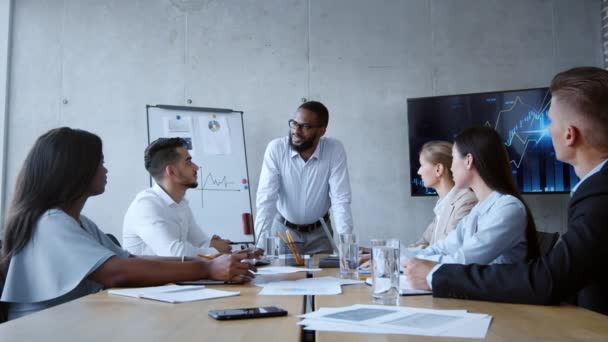 Positiv afrikansk amerikansk affärsman talar med ung manlig chef under teambuilding diskussion på kontoret, zooma in — Stockvideo