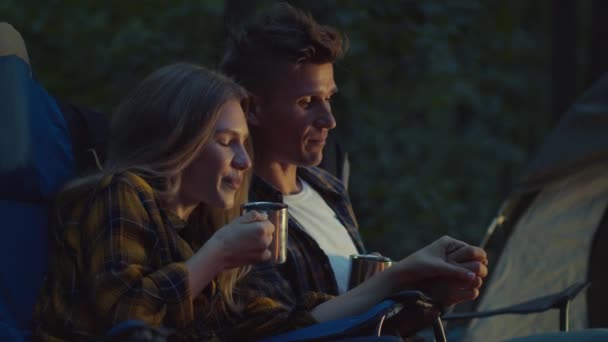 Harmonia i pokój. Młodzi turyści siedzący na obozie leśnym i pijący herbatę, obejmujący i cieszący się wspólnym czasem — Wideo stockowe