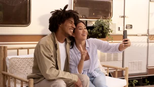 Mladý multietnický pár s úsměvem a s selfie na smartphone v kempu — Stock video