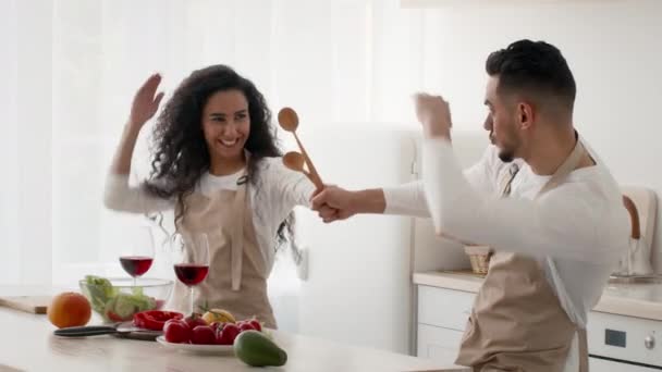 Arab Couple Fighting On Spoons For Fun Cooking In Kitchen — Stock Video