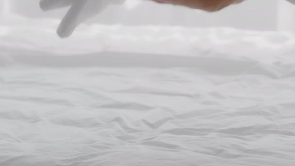 Kobiety ręce wprowadzenie stosu świeżych białych ręczników kąpielowych na łóżku, zbliżenie — Wideo stockowe