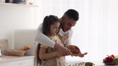 Orta Doğulu baba ve kızı mutfakta akşam yemeği hazırlarken eğleniyor.