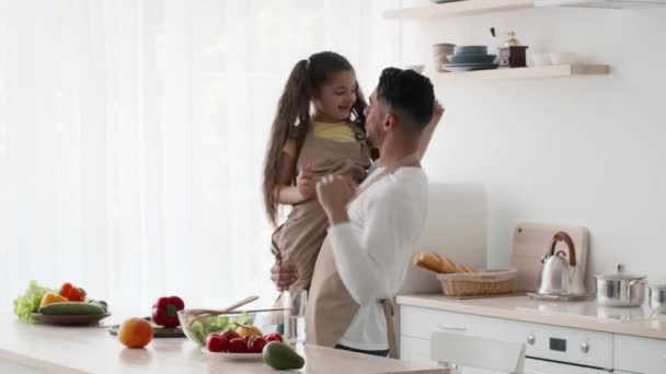 Šťastný arabský otec, který drží dceru při tanci, baví se v kuchyni — Stock video