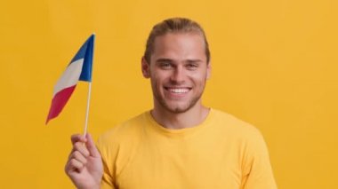 Fransız bayrağını sallayan yakışıklı, vatansever bir genç.