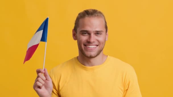Bonito jovem patriótico cara acenando com a bandeira da França na câmera — Vídeo de Stock