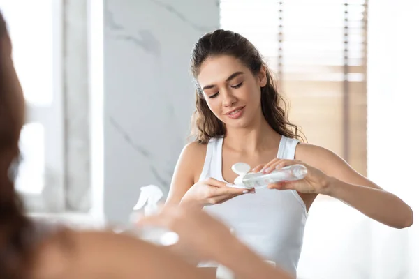 Frau reinigt Gesichtshaut mit Micellar Water im modernen Badezimmer — Stockfoto