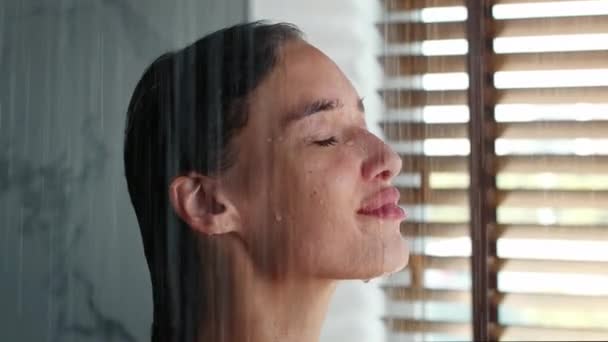 Młoda dama relaksujący prysznic z zamkniętymi oczami w łazience — Wideo stockowe