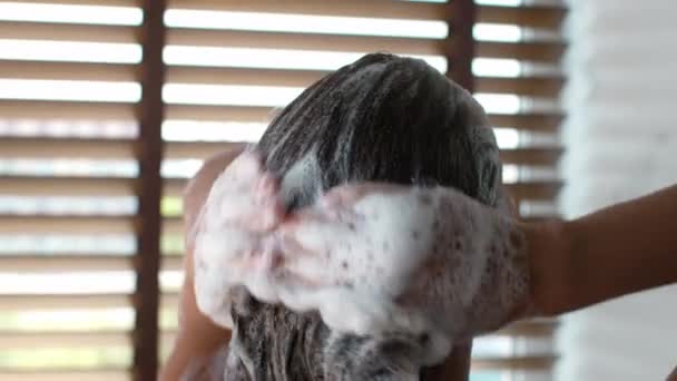 Vissza Kilátás a női mosás haj segítségével sampon a fürdőszobában — Stock videók