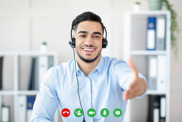 Arabische man in koptelefoon hebben van online vergadering, het sluiten van zakelijke deal, het aanbieden van handdruk op kantoor, pc scherm bekijken — Stockfoto