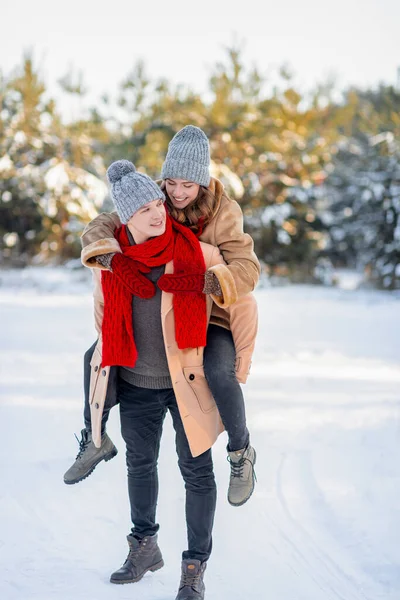 Pozitivní milující pár těší zasněžené zimní den v parku spolu — Stock fotografie