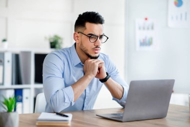 Gergin Arap adam dizüstü bilgisayar kullanıyor, iş konusunda sorun yaşıyor, iş projesinde hata yapıyor.