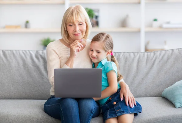 快乐成熟的女人和孙女用笔记本电脑 — 图库照片