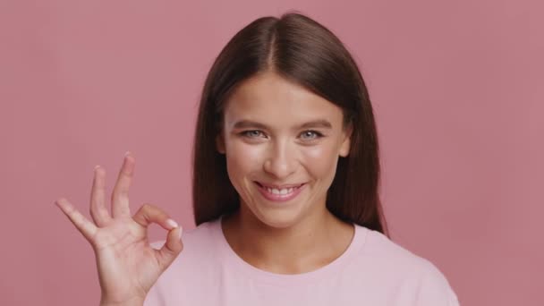 Счастливого женского жеста в порядке для камеры кивая головой, розовый фон — стоковое видео