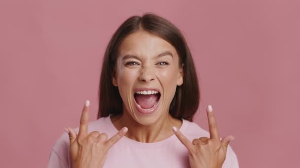 Emotional Young Female Showing Rock Gesture Posing Over Pink Background — Stock Video