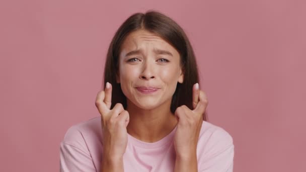 Lady Keeping Fingers Crossed Making Wish Over Pink Studio Background — Stock Video