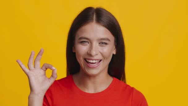 Señorita Positiva Gestos OK Símbolo Posando sobre fondo amarillo — Vídeo de stock