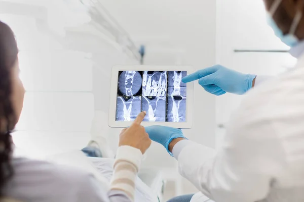 牙科医生及女病人在数码版张上看牙齿X光照片 — 图库照片