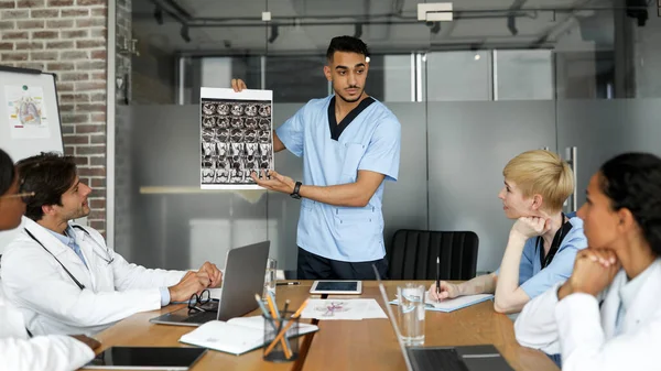 Hombre árabe médico mostrando a sus colegas resonancia magnética —  Fotos de Stock