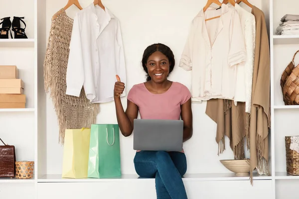 African American Woman Shopping Online Using Laptop Gesturing Thumbs-Up in door — стокове фото