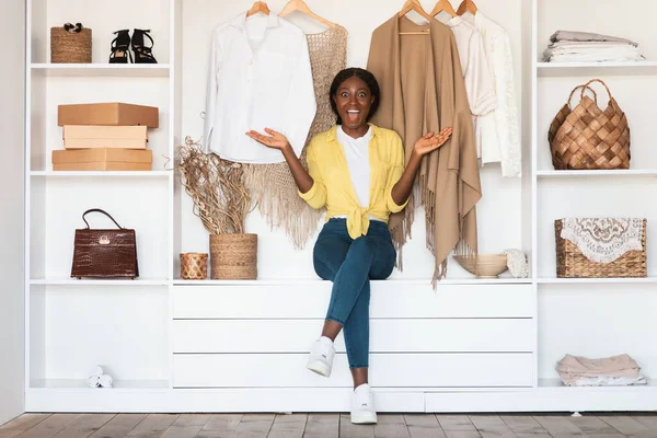 Excited African American Lady Posing In Wardrobe Among Clothes Indoor