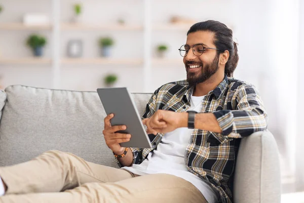 Avslappnad indian man kylning hemma med digital tablett — Stockfoto