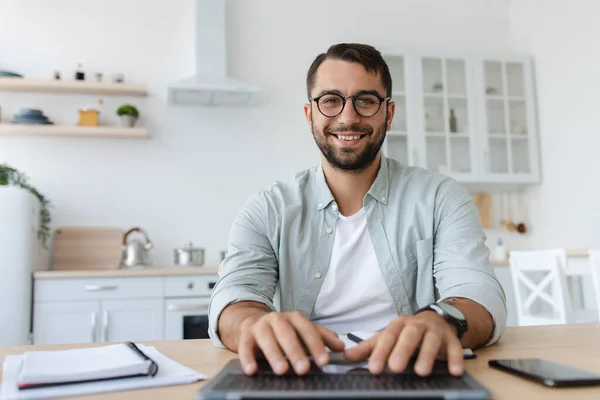 Fröhlicher reifer Kaukasier mit Bart in Brille tippt auf Tastatur, arbeitet am Laptop, schaut auf Webcam — Stockfoto