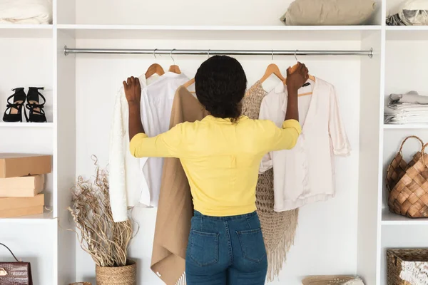 African Woman Choosing Clothes Standing Back To Camera In Wardrobe — Stock Photo, Image