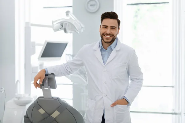 Guapo caucásico hombre médico posando en más reciente clínica dental — Foto de Stock