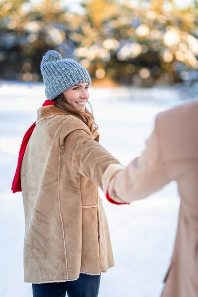 Sonriente joven bonita dama tirando de la mano masculina, disfrutando de la nieve juntos —  Fotos de Stock