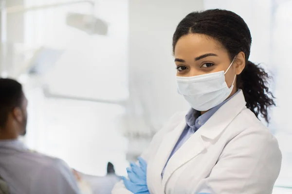 Conceito de Odontologia. Retrato do dentista feminino preto na máscara médica protetora — Fotografia de Stock