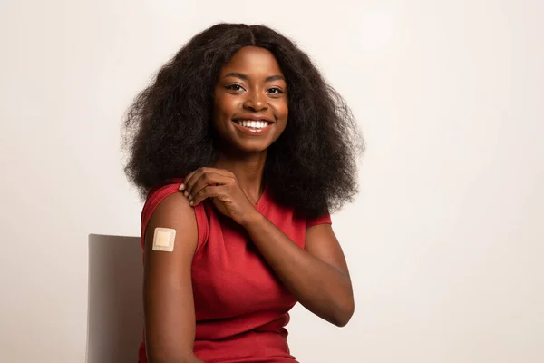 Vaccinatie. Glimlachende zwarte dame demonstreren arm met lijm verband na Covid-19 Vaccine — Stockfoto