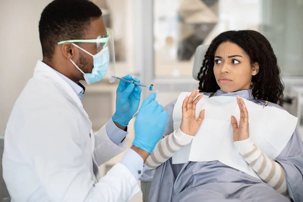 Ανησυχημένη μαύρη γυναίκα ασθενής κοιτάζοντας οδοντίατρος με σοκ — Φωτογραφία Αρχείου
