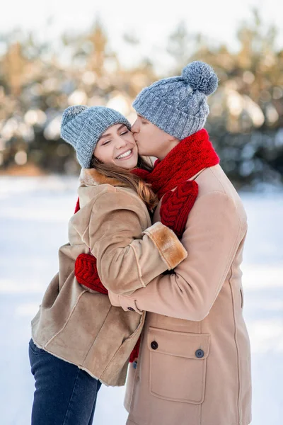 爱的男人亲吻他微笑的女朋友的衣服，冬季枪战 — 图库照片