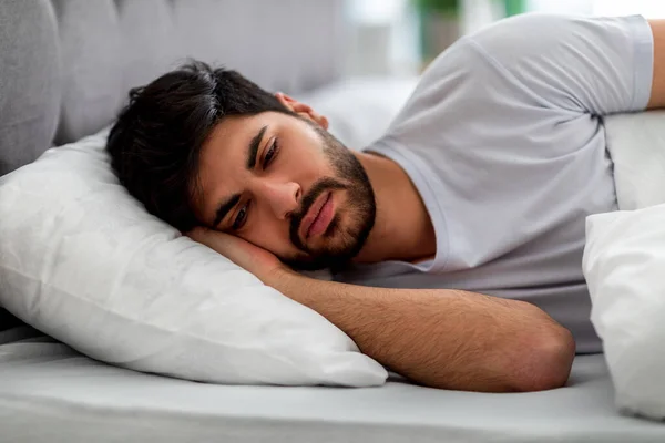 Droevige Arabier die alleen in bed ligt, lijdt aan eenzaamheid en denkt aan problemen. Concept mannelijke stress en depressie — Stockfoto