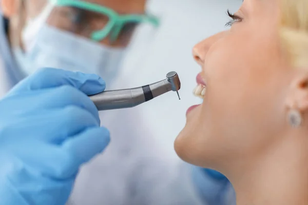 Fechamento do paciente olhando para o dentista enquanto ele perfura o dente — Fotografia de Stock