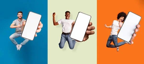 Satisfied happy excited diverse people jumping, have fun and show smartphone with blank screen — Stock Photo, Image