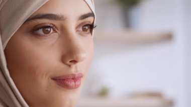 Ortadoğulu güzel bir kadının yarı profilli portresi boş alana bakıyor ve gülümsüyor.