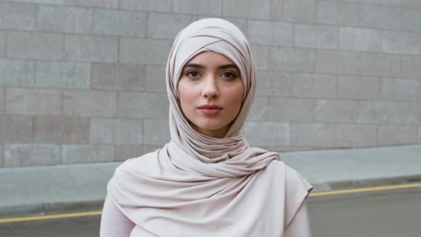 Внешний портрет молодой уверенной мусульманки, носящей хиджаб, прикладывающей палец к губам, показывающей жест тсс. — стоковое видео