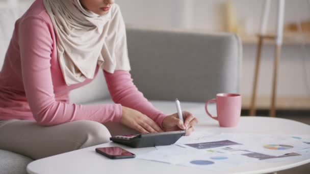 Unrecognizable muslim woman working at home, calculating finances and taking notes, making business plan, free space — Stock Video